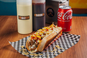 Perrito caliente estilo venezolano con salsas y patatas.